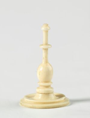  A single white chess king piece with a subtle cross on top, set against a light, plain background, showcasing its elegant design and creamy, polished surface.