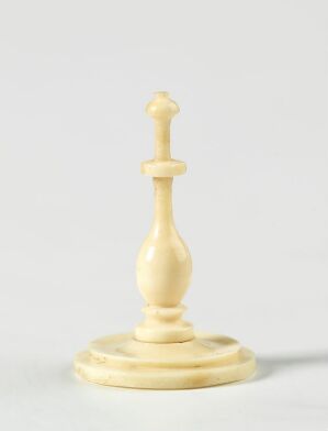  A single ivory-colored chess king with a light sheen stands against a plain, light-gray background, emphasizing its elegant design and regal status.