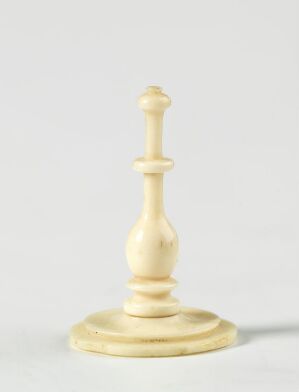  A white chess king on a light gray background, detailed with a smooth off-white surface and a design that includes a round base, several tiered sections, and a cross on top.