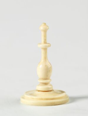  An ivory-colored king chess piece on a pale gray background, detailed with a softly lit, finely crafted texture, representing the highest rank in the game of chess.