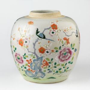  A rounded ceramic vase with a fluted opening featuring a painted scene of multicolored flowers and a cobalt blue bird on a creamy background. The vibrant floral arrangement includes shades of pink, orange, green, and blue, creating a lively, elegant design. Artist name and title of the vase are unknown.