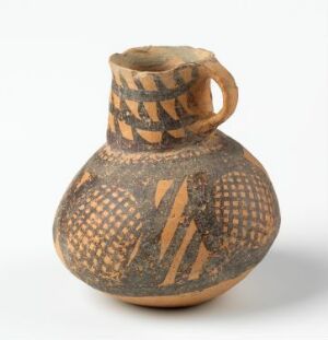  An ancient, small, round-bodied pottery vessel with a single loop handle and a wide mouth. The surface features earthy beige tones and is adorned with brown to black geometric patterns, including checkerboard and zigzag designs.