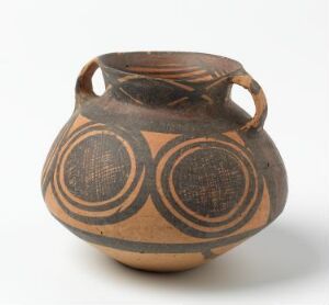  An ancient beige ceramic pot with symmetrical dark brown geometric patterns, featuring two small side handles and intricate concentric circle motifs.