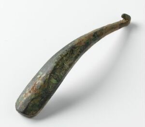  An object resembling a banana with a textured surface in hues of green, brown, and gray, possibly made of stone, set against a plain off-white background. Artistname and title are unknown.