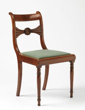  A classic glossy mahogany wooden chair with a neoclassical design, featuring a circular wooden rosette on the top of the backrest, minimalist lyre-like openwork, and a seat upholstered in pale green fabric.