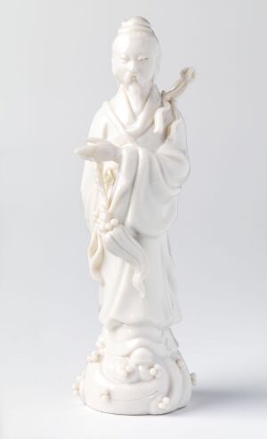  A porcelain figurine of Lü Dongbin, an iconic figure in Chinese mythology, standing on a cloud motif base, depicted with traditional attire, holding a flute, and exhibiting a serene demeanor in a pure white finish against a soft gray background. Artist unknown.