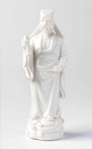  White porcelain statuette of "Cao Guojiu" by an unknown artist, depicting a male figure in traditional robes with a serene expression, holding an object to his chest, standing on a circular base against a light background.