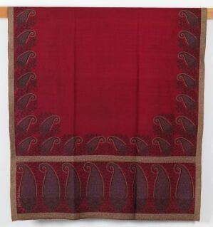  A square textile with a deep red center and a decorative band of paired paisley motifs in maroon and brown along the bottom edge, set against a neutral background.