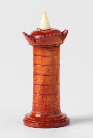  A glossy, burnt orange tower-shaped object with deep red accents on a light gray background, featuring a pattern of lighter orange bands around its body and stylized projections on top, ending with a cream-colored conical tip. Artist and title are unknown.