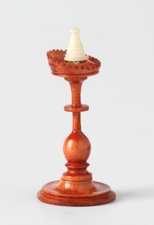  A traditional wooden candlestick holder with a white taper candle set against a light grey background. The brown wooden holder displays a glossy finish with a round base, and a delicately shaped stem, while the unlit white candle sits nestled in the scalloped top.