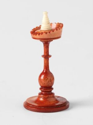  A wooden candlestick holder with a small white candle inserted, all set against a plain white background. The holder has a classic design with a scalloped edge on the receptacle and a polished mahogany-like finish.