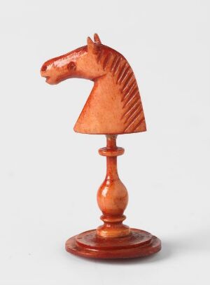  A polished reddish-brown wooden knight chess piece, with detailed carving, displayed against a plain white background.