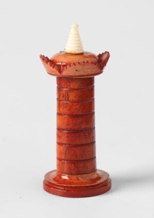  A small, ceramic-like model of a lighthouse with a terracotta orange body with ridges and an off-white conical top, on a white background.