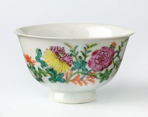  A porcelain bowl with a hand-painted floral pattern featuring a prominent pink rose, purple and yellow flowers, and green foliage on its outer surface, displayed against a white background.