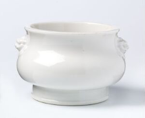  A white ceramic vessel with stylized handles on a plain white background.