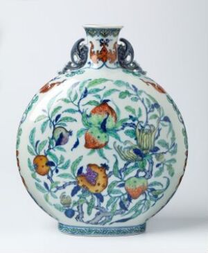  A traditional porcelain vase with a white background and detailed patterns in cobalt blue, orange, green, and yellow featuring flowers, leaves, and fruits, with a reflective glazed surface. Artist name and title are unknown.