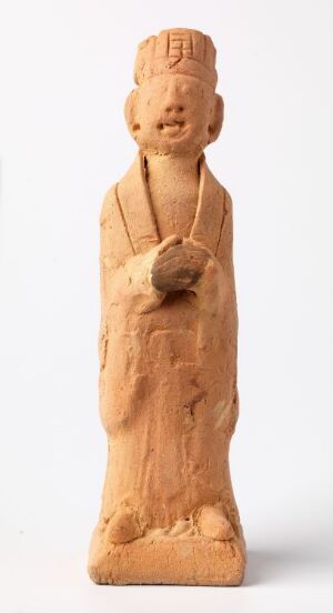  An intricately carved, light brown wooden figurine on a white background, depicting a stylized human figure with a rectangular head, detailed headdress, and arms held in front of the stomach.