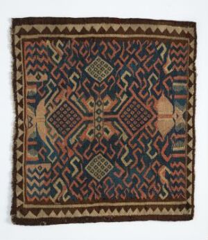  An intricately patterned square textile with a symmetrical design, featuring diamond shapes and a rich color palette with earthy tones and bright accents, possibly a handcrafted rug or tapestry.