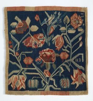  Square woven or embroidered textile with a deep blue background, adorned with intricate floral patterns in oranges, yellows, greens, and pinks, with the initials "K.D" in the bottom right corner.