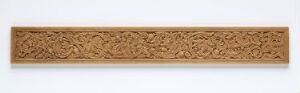  Intricate golden-brown carved wooden panel with a detailed floral or foliate relief design, indicative of traditional or classical wood craftsmanship, uniformly lit to highlight the texture and depth of the carving. Artist name and title are unknown.