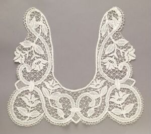  Intricate lace collar with a symmetrical floral and filigree design on a neutral background.