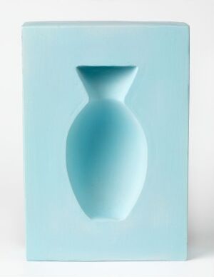  A decorative ceramic art piece called "Optica" by Elisabeth von Krogh, featuring a rectangular, baby blue earthenware plaque with a three-dimensional optical illusion of a curvaceous vase in varying shades of blue creating depth and shading, embodying a modern and tranquil design.