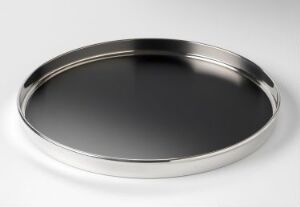  A round, polished stainless steel tray with a reflective surface and raised edge, sitting on a soft white background.