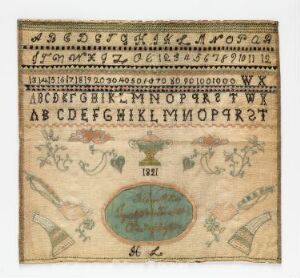 
 An antique sampler featuring rows of alphabets, numbers, and decorative patterns on natural beige fabric, with a central oval dated '1821' and bordered by fan-like floral embroideries in faded tones of green, pink, and tan.