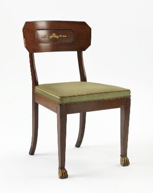  A classic wooden chair with a decorative floral inlay in the backrest and olive green upholstered seat. It features tapered legs and ornate lion's paw feet with brass casters. The chair is set against a light background, highlighting its elegance and vintage design.