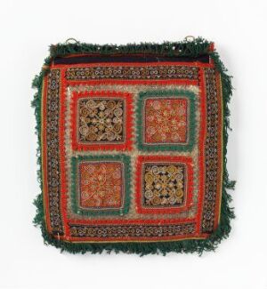  A square textile artwork with a green base and a rusty red border featuring intricate patterns. It includes four interior panels with floral and geometric designs against beige backgrounds, surrounded by green thread tassels.