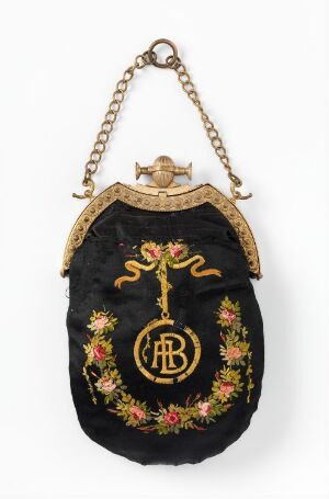  A small black fabric purse with a golden metal frame and chain handle, featuring ornate floral embroidery with an interlinked "A" and "B" monogram on the front.