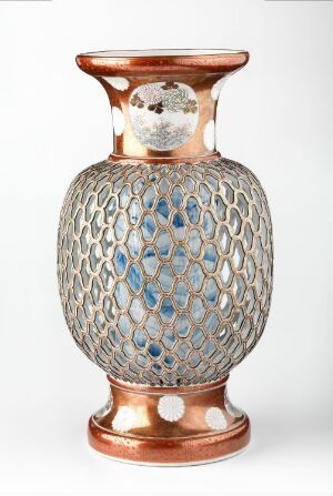  An ornate ceramic vase with a copper-like glossy finish on the foot and neck, and a trellis-patterned body revealing an inner blue glaze.