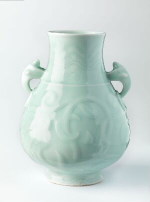  A gently-lit pale green celadon vase with a rounded body and flared neck, decorated with raised cloud-like patterns, set against a plain white background. Artist name and title are unknown.