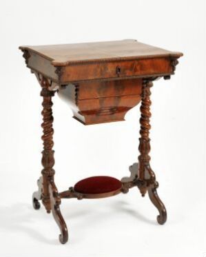  Antique wooden sewing table with spiral-carved legs and scrolled feet, featuring a single drawer with brass pulls, and a circular burgundy fabric-lined bottom compartment, against a white background. Artist name and title are unknown.