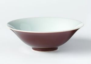  An elegant bowl with a deep maroon exterior and soft pale blue interior, set against a neutral background, demonstrating a classic design with a sharp contrast between colors.