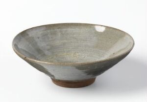  A ceramic bowl with a broad, tapered shape, featuring a semi-glossy glaze with shades of gray and off-white, accented by darker gray streaks, and exposing the natural warm brown tone of the clay at the rim and base. Artist name and title are unknown.