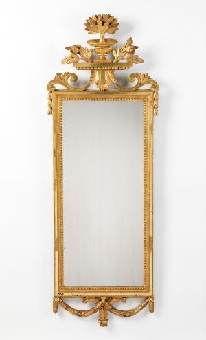  An ornate, gilded rectangular mirror with a tall, clear glass pane and elaborate top and bottom decorations featuring stylized floral and leaf motifs, likely from the Rococo or Baroque period. The entire piece exudes opulence and historical elegance.