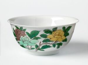  A medium-sized ceramic bowl with a white base color, adorned with a hand-painted floral design in green, pastel blue, golden yellow, and light red, set against a light gray background.