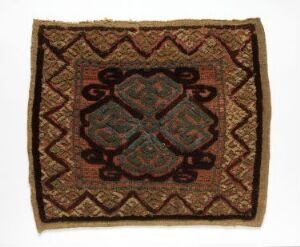  Antique octagonal woven textile or rug with a central green, red, and blue diamond-shaped medallion and surrounding earth-toned zigzag borders, showing historical craftsmanship.