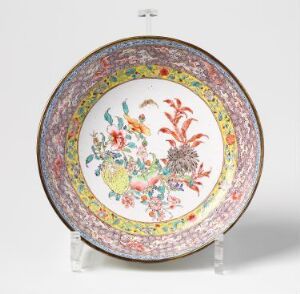  A richly decorated circular plate with a detailed floral pattern on the rim and a vibrant bouquet in the center, set against a solid white background and supported by an invisible stand.