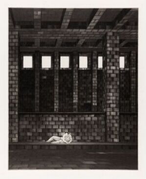  "As long as it spins life, never say never I" by Arne Bendik Sjur is a drypoint on paper artwork depicting a somber, industrial interior with a single human figure lying on the floor. The space is characterized by tall windows with light streaming in, creating a pattern of light and shadow that highlights the textures of the brick walls and the solitude of the figure.