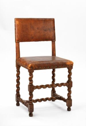  A vintage wooden chair with a square seat and turned spindle supports, exhibiting a warm brown color against a neutral background.