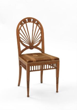  A medium brown wooden chair with a sunburst pattern of slats on the backrest and a caned seat, set against a plain, light background.