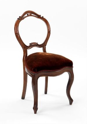  An antique-style wooden chair with a glossy brown finish, featuring an oval-shaped backrest and plush brown velvet upholstery on the seat, set against a plain white background.