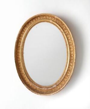  An antique oval golden picture frame without a picture, displaying intricate scrollwork and floral motifs, against a white background.