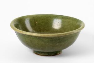  A mossy green glazed ceramic bowl with a glossy finish, flaring outward from a small circular base, against a light neutral background.