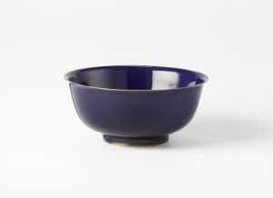  A glossy cobalt blue bowl with a slightly flared rim on a plain off-white background.