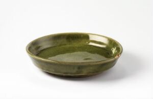  A shallow olive green ceramic bowl with a glossy finish, situated against a neutral off-white background.