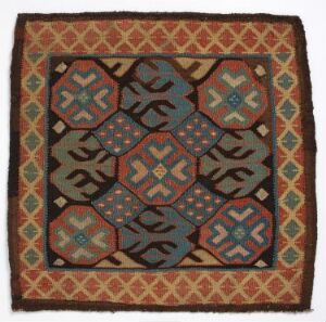  An image of a square textile, possibly a rug or tapestry, displaying a symmetrical pattern with earthy tones, including shades of brown, terracotta, muted green, blue, and cream, featuring a geometric border and a central field of interlocking octagonal shapes with intricate motifs.