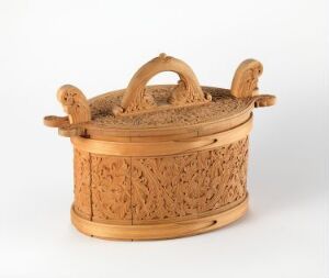  An intricately designed oval wooden basket with a lattice pattern and a solid arched handle set against a plain white background. No artist name or title is provided.